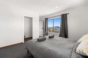 a bedroom with a bed and a large window at Lakeview Oasis in Rotorua