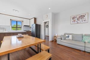 a kitchen and living room with a table and a couch at Lakeview Oasis in Rotorua