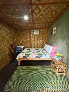 a bedroom with a bed in a room with wooden walls at Bulkan Villa Rental in General Luna
