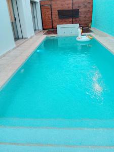 ein blauer Pool mit Spielzeug im Wasser in der Unterkunft Green Hôte piscine sidi bou said in Dar Salah Bey