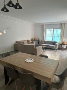 ein Wohnzimmer mit einem Holztisch und einer Couch in der Unterkunft Green Hôte piscine sidi bou said in Dar Salah Bey