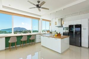 a kitchen with white cabinets and a ceiling fan at V270 Best View In Phuket Hot Tub Great Location in Ban Saiyuan (1)