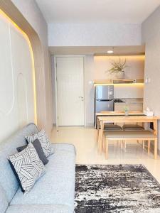 a living room with a blue couch and a table at Aesthetic korean apartment 2 BR in Surabaya