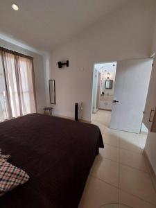 a bedroom with a black bed and a bathroom at Encantadora Casa en La Yesca cerca de poliforum in Santa Julia