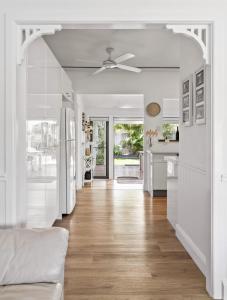 a kitchen with white walls and a ceiling fan at Spa & Chill Lodge in Budgewoi