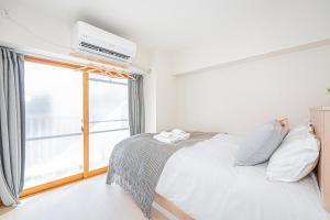 ein Schlafzimmer mit einem Bett und einem großen Fenster in der Unterkunft 田端精装套房 403 in Tokio