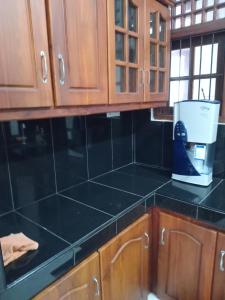 eine Küche mit einer schwarzen Arbeitsplatte und einem Mixer in der Unterkunft Sunshine Holiday Resort -Sella Kataragama in Kataragama