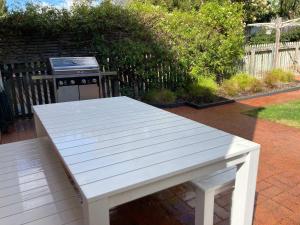 a white bench in a backyard with a stove at Cosy renovated 2 bed villa in superb location in Hobart