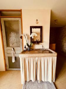 un bagno con lavandino e specchio di Maison de Vignerons La Grange a Noyers-sur-Serein Altre 8 foto