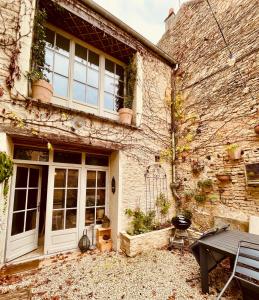 un edificio di mattoni con una porta e un tavolo di Maison de Vignerons La Grange a Noyers-sur-Serein