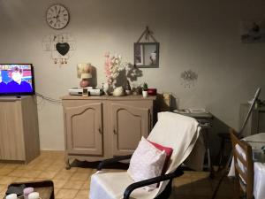 a living room with a chair and a tv at 196 rue des moulins in Vachères