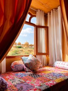 a bedroom with a window with a view of the desert at Hotel Royal Heritage in Jaisalmer +96 photos