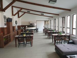 a dining room with tables and chairs and windows at Aranydukát Vendégház Tállya in Tállya