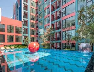 a large swimming pool in front of a building at Cybiq Ratchada 32 by Pikul in Bangkok