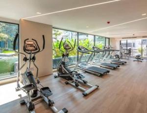 a gym with a row of treadmills and elliptical machines at Cybiq Ratchada 32 by Pikul in Bangkok