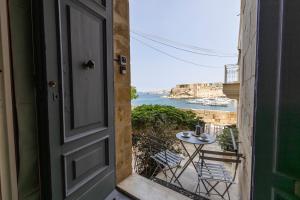 an open door to a balcony with a table and chairs at Harbour Mansion in Birgu