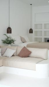 una sala de estar con un sofá blanco con almohadas en La Bianca Studio Apartment, en Dalung
