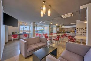 a lobby with chairs and tables and a bar at City Express Junior by Marriott Mexicali in Mexicali