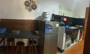 a small kitchen with a table and a refrigerator at Camiguin Atlantis Pension House in Catarman