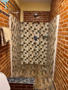 a bathroom with a shower in a brick wall at Les Terrasses Himalayan Resort in Charikot