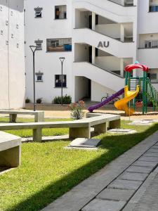 a park with benches and a playground in front of a building at Buxton point apartment in Mombasa