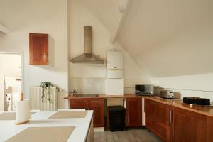 Una cocina con gabinetes de madera y encimera. en Grand studio center of Mons, en Mons