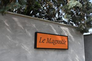 un cartello sul lato di un muro di Le Magnolie a Cioccaro