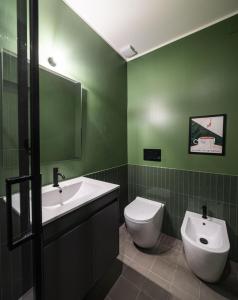a green bathroom with a toilet and a sink at LUZ 03 room in Bologna +9 photos