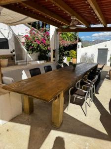 a large wooden table on a patio with chairs at MASIA LA MOLINERA in Xerta