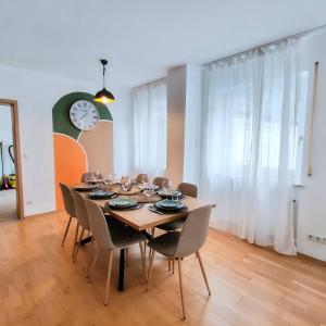 Una mesa de comedor con sillas y un reloj en la pared. en Drei Flüsse Oase, en Passau 6 fotos más