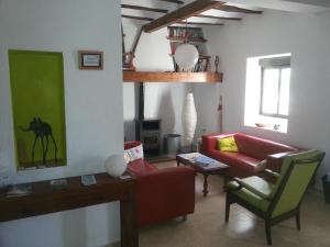 ein Wohnzimmer mit einem roten Sofa und einem Stuhl in der Unterkunft Villa Carmen in Bocairent