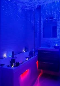 a bathroom with a bath tub with red lights at Loveroom Adults Only jacuzzi vieille ville Annecy in Annecy
