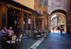 a group of people sitting at tables on a street at Loveroom Adults Only jacuzzi vieille ville Annecy in Annecy