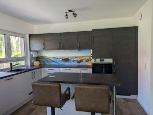 a kitchen with a table and some chairs in it at "Natur-Retreat am Bodden mit Kranichbeobachtung"-Haus kleiner Kranich in Neuendorf Hof +29 photos