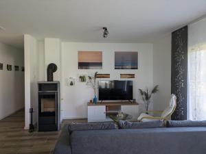 a living room with a couch and a tv at "Natur-Retreat am Bodden mit Kranichbeobachtung"-Haus kleiner Kranich in Neuendorf Hof