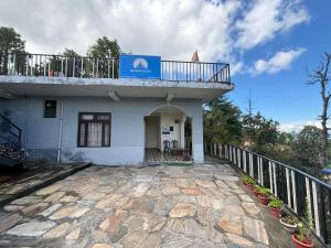 a building with a balcony on top of it at Odyssey Stays Majkhali, Ranikhet in Chaubattia