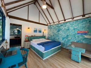 Un dormitorio con una cama y una pared azul. en Heaven Beach Resort & Art, en Ko Phayam 31 fotos más