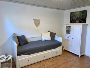 a bedroom with a bed and a white cabinet at Moderne Ferienwohnung in historischer Altstadt - keine Monteurswohnung in Hilpoltstein +13 photos
