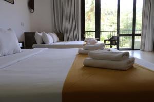 a hotel room with two beds with towels on it at Handagedara Resort & Spa in Mirissa
