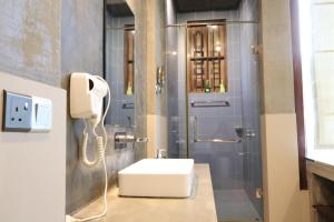 a bathroom with a white sink and a phone at Handagedara Resort & Spa in Mirissa