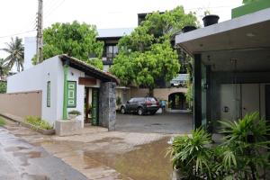 a building with a car parked in a parking lot at Handagedara Resort & Spa in Mirissa