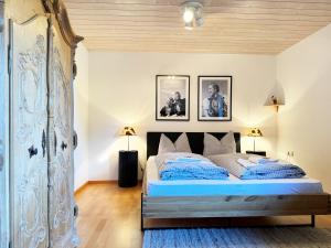 a bedroom with a bed and two pictures on the wall at Alpines Wohlfühl-Apartment OPlus in Oberstaufen +12 photos