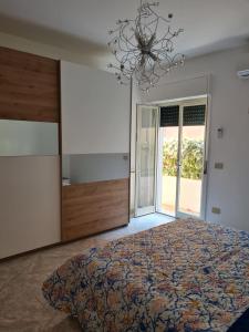 a bedroom with a large bed and a chandelier at Elisabeth House in Giardini Naxos