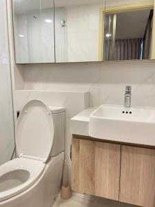 Un baño con un inodoro blanco y un lavabo. en Botique condo in Asoke, en Bangkok