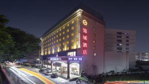 深圳Shenzhen Jincheng Hotel的侧面有红色标志的建筑物