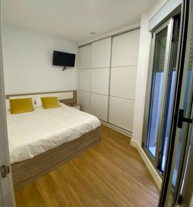 a bedroom with a bed and a tv on the wall at Suite Beethoven in Santa Cruz de Tenerife