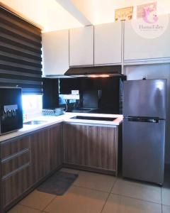 a kitchen with white cabinets and a stainless steel refrigerator at The Majestic Condo Ipoh Home Fairy 3 in Ipoh