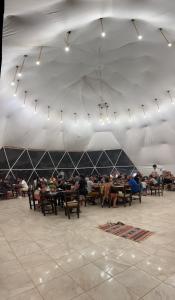 a group of people sitting at tables in a tent at Angelina Luxury Camp in Wadi Rum