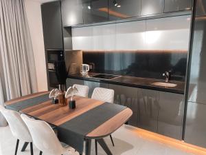a kitchen with a wooden table and a sink at Sky Suites-KASS Towers in Okponglo