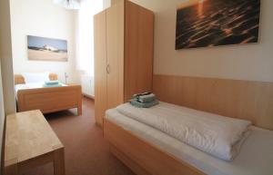 a bedroom with a bed and a cabinet and a table at Haus Nordmeer in Borkum
